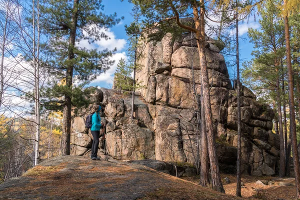 Uzun yürüyüşe çıkan kimse kız yanındaki taş duruyor