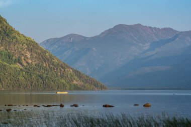 Balıkçı Frolikha gölünde bir katamaran üzerinde yelken açıyor.