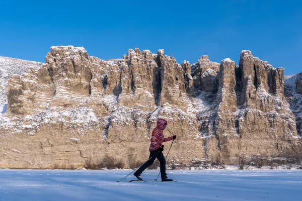 Dívka běží lyžování na pozadí krásných skal — Stock fotografie