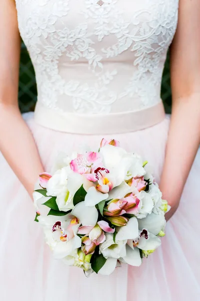 Mooie jonge vrouw draagt een bruiloft jurk die zich voordeed op grunge achtergrond Stockafbeelding