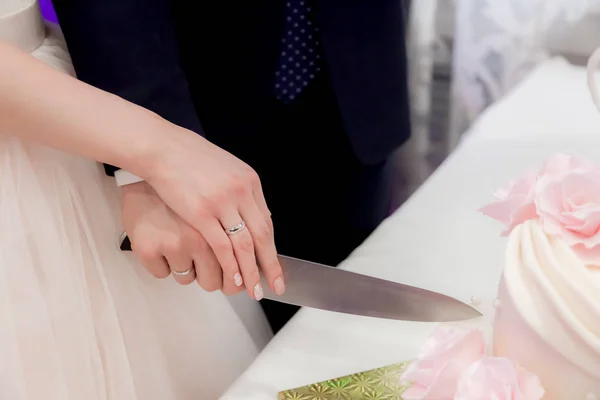 Jonggehuwden snijden van de taart met blauwe bloem bruid droom Stockfoto