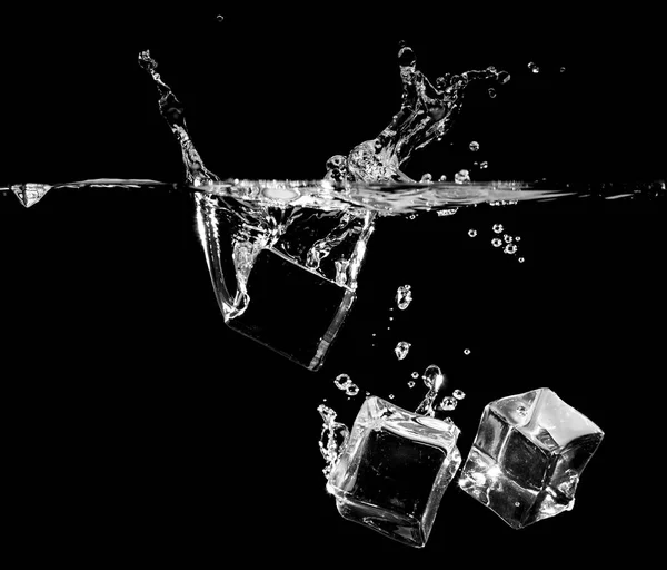 Брызги льда в воде на черном фоне — стоковое фото