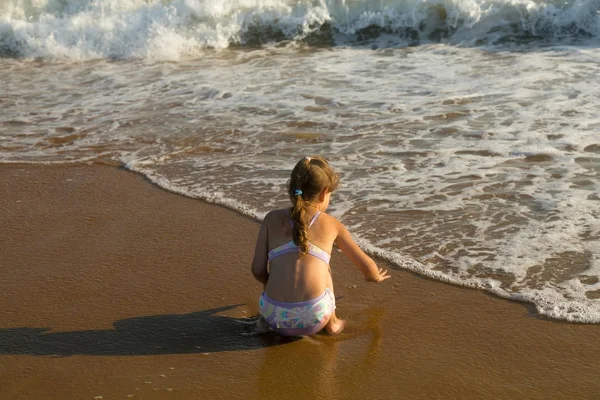 Baby spelen met golven op zee zomer Stockfoto