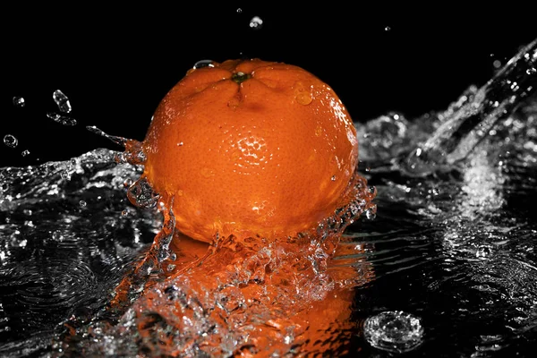 Mandarine fällt auf schwarz ins Wasser — Stockfoto