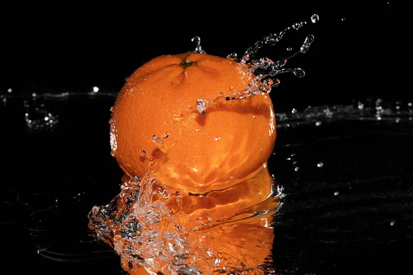 Mandarine fällt auf schwarz ins Wasser — Stockfoto