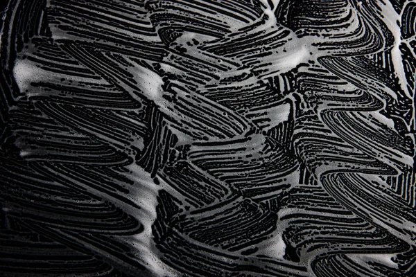 Beyaz sabun doku siyah arka planda el yapımı hipster köpük doku soyut ışık saçan beyaz köpük