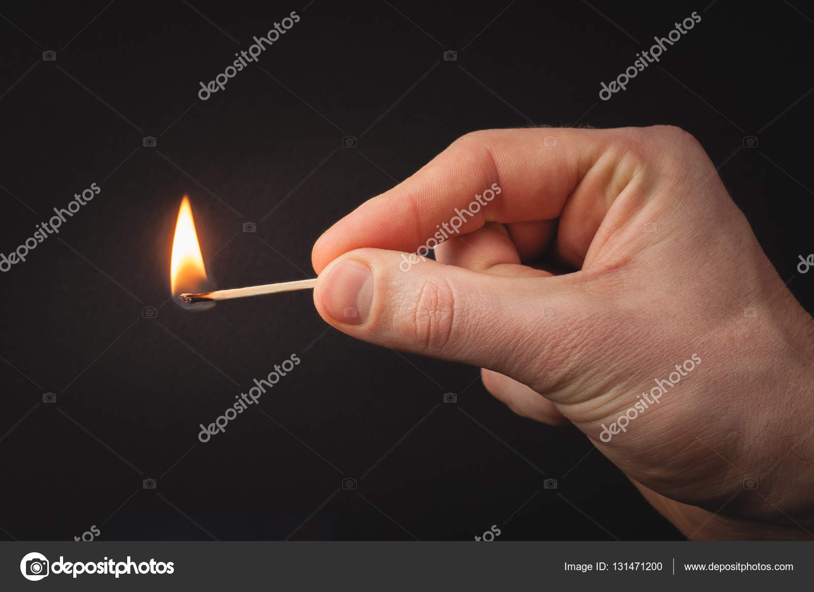 Hand holding burning match stick. Photo on a black background Stock