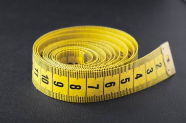 Siyah zemin üzerine sarı ölçü birimi teyp