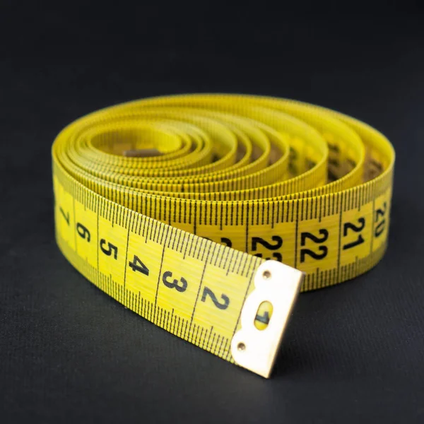 Fita métrica amarela no fundo preto — Fotografia de Stock