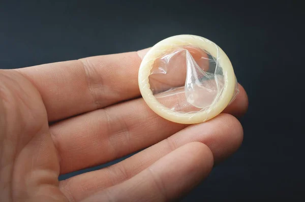 Genç adam el prezervatif vermek. Fotoğraf. Sadece yetişkin için oyuncaklar
