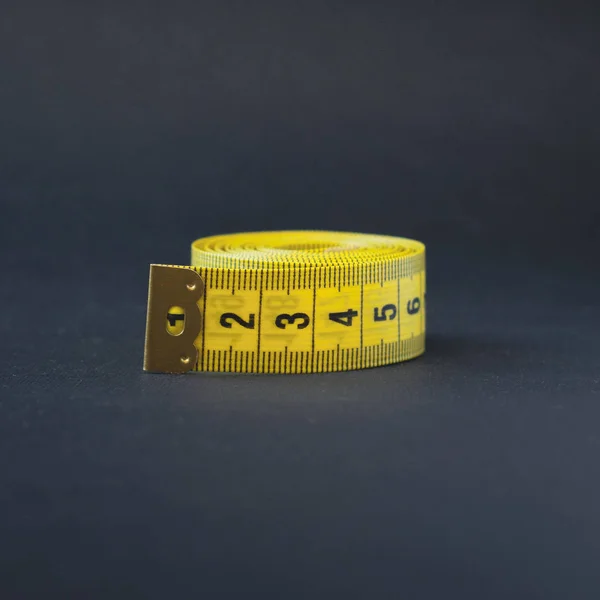 黒のテープ メジャーの小さな黄色のロール。cantimeters. ロイヤリティフリーのストック写真