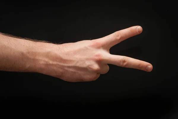 Right male arm showing countdown position two isolated on wide abstract absolutely seamless black background. — Stock Photo, Image