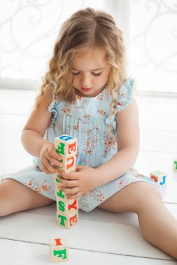 ABC küpleri ile oynayan ve yetiştirmek küçük şirin kız. Güzel gi