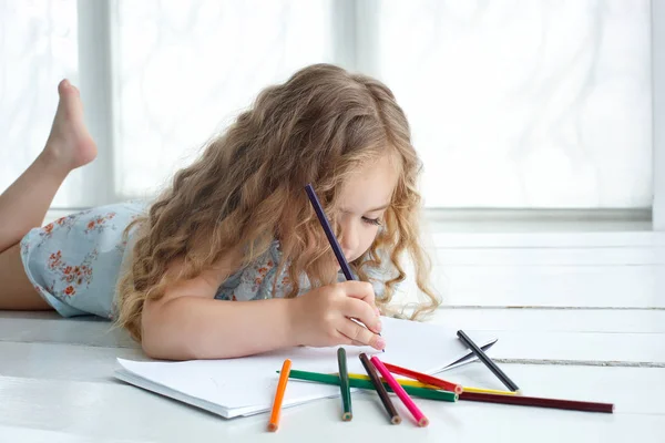 Mała dziewczynka ładny rysunek obraz z kolorowych ołówków, układanie — Zdjęcie stockowe