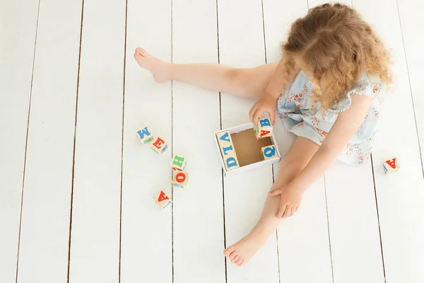 Niña linda jugando con cubos abc y educar. Bastante gi — Foto de Stock