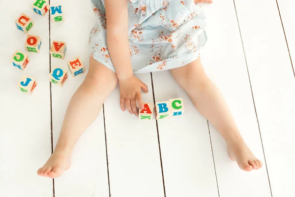 Niña linda jugando con cubos abc y educar. Bastante gi — Foto de Stock