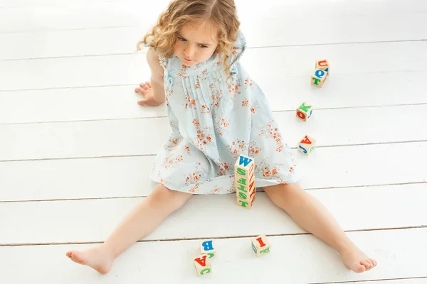 ABC küpleri ile oynayan ve yetiştirmek küçük şirin kız. Güzel gi — Stok fotoğraf