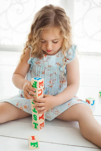 Niña linda jugando con cubos abc y educar. Bastante gi — Foto de Stock