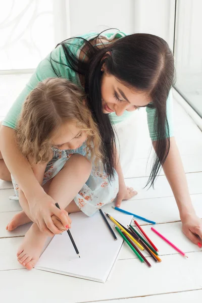 可爱的小女儿和她的母亲用彩色铅笔绘图 — 图库照片