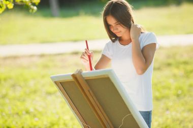 Genç ve güzel kadın, şövale renkli boya açık ile çizim