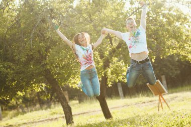 Gülümseyen güzel iki birbirlerine el ile alarak atlama. Bea