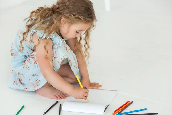 Мила дівчинка малює барвистими олівцями на папері. Досить — стокове фото