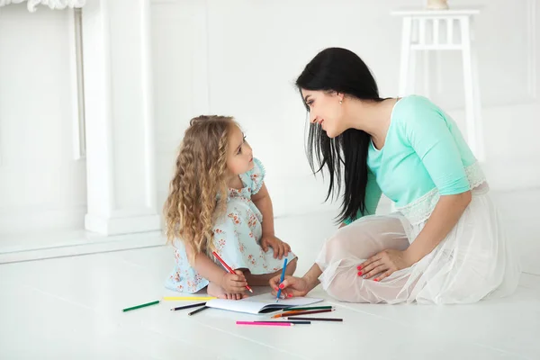 Küçük şirin kızı ve annesi renkli kalemle çizim — Stok fotoğraf