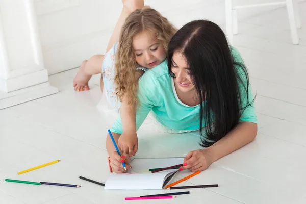 Küçük şirin kızı ve annesi renkli kalemle çizim — Stok fotoğraf