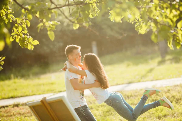 Young pretty couple having fun outdoors with paintings. Handsome — Stock Photo, Image