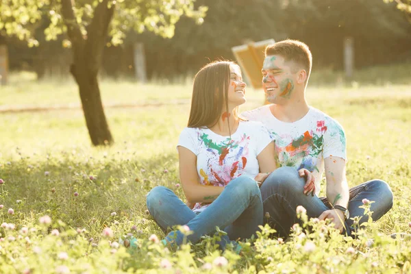 Bonita pareja sentada en el césped al aire libre. Hermosa chica y — Foto de Stock