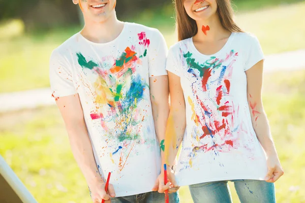 Unrecognizable man and woman shawing their painted colorful t-sh