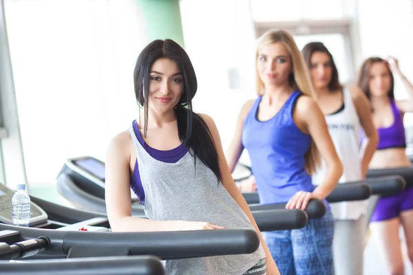 Un grupo de hermosas chicas en buena forma corriendo en el trea —  Fotos de Stock