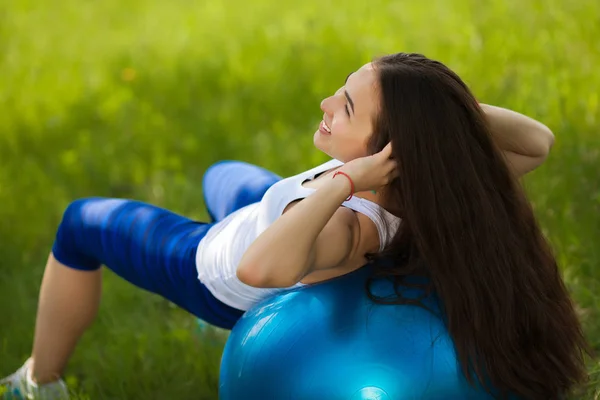 Jong meisje uit buitenshuis te werken. Mooie vrouw doen pilates, — Stockfoto