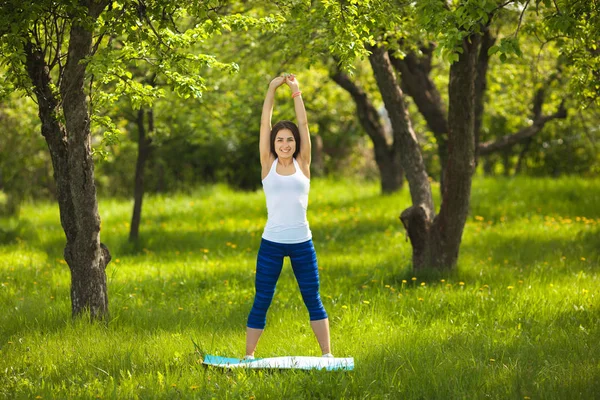 Chica joven haciendo ejercicio al aire libre. Hermosa mujer haciendo pilates , — Foto de Stock