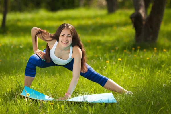 Jong meisje uit buitenshuis te werken. Mooie vrouw doen pilates, — Stockfoto