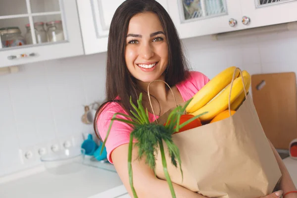 Mujer bastante joven con enorme bolsa de frutas y verduras frescas . — Foto de Stock