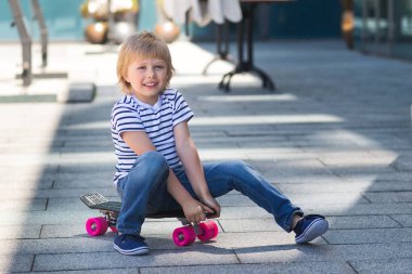 Paten boyutunda bir tahta üzerinde çok güzel bir çocuk. Açık havada duygusal çocuk. Şirin