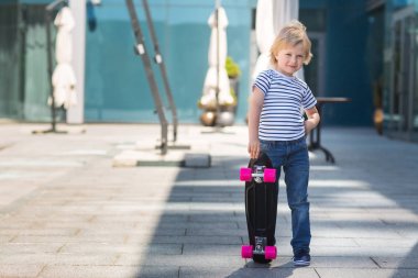 Paten boyutunda bir tahta üzerinde çok güzel bir çocuk. Açık havada duygusal çocuk. Şirin