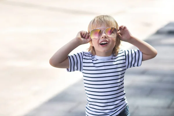 Un niño bonito en una tabla de skate. Niño emocional al aire libre. Lindo. —  Fotos de Stock