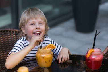 Taze limonata içmeye kafede çok şirin küçük çocuk. Duygusal