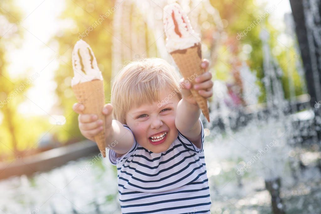 Very cute little boy eating icecream. Adorable kid with two icec