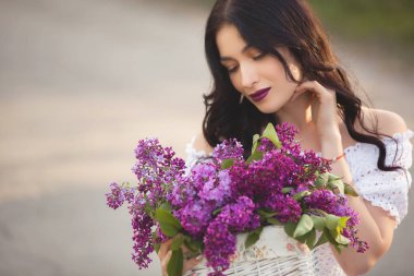 Güzel kız açık havada. Lila buket ile genç ve güzel kadın