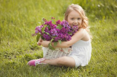 Sevimli küçük kız açık havada bahar çiçekleri ile. Güzel çocuk ile