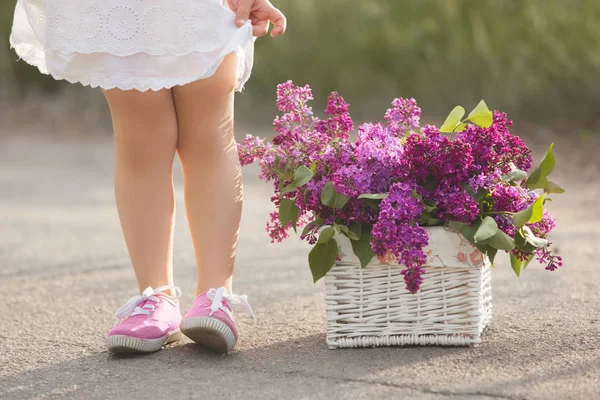 Sevimli küçük kız açık havada bahar çiçekleri ile. Güzel çocuk ile — Stok fotoğraf