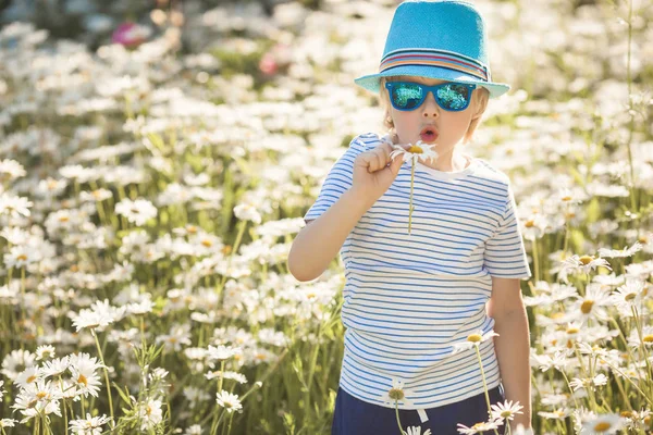Емоційна дитина в ромашковому полі. Весела дитина з квітами — стокове фото