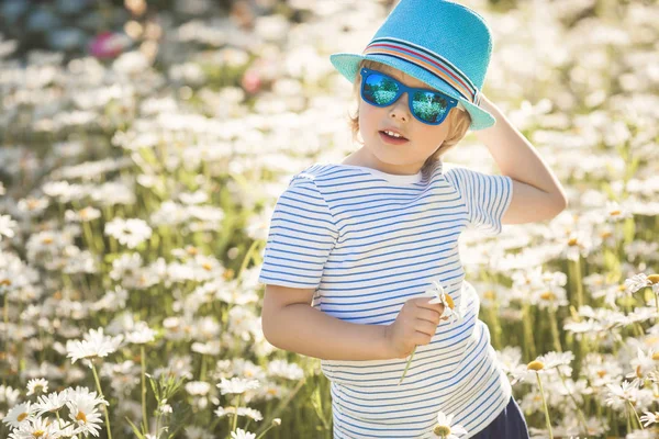 Enfant émotionnel dans le champ de camomille. Enfant joyeux avec des fleurs — Photo