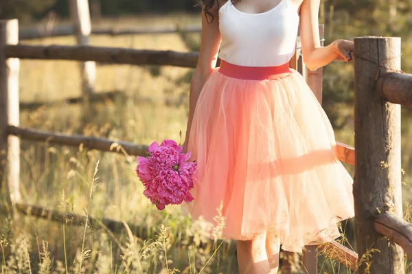 Bella ragazza con pioni sulla natura otdoors al sole — Foto Stock