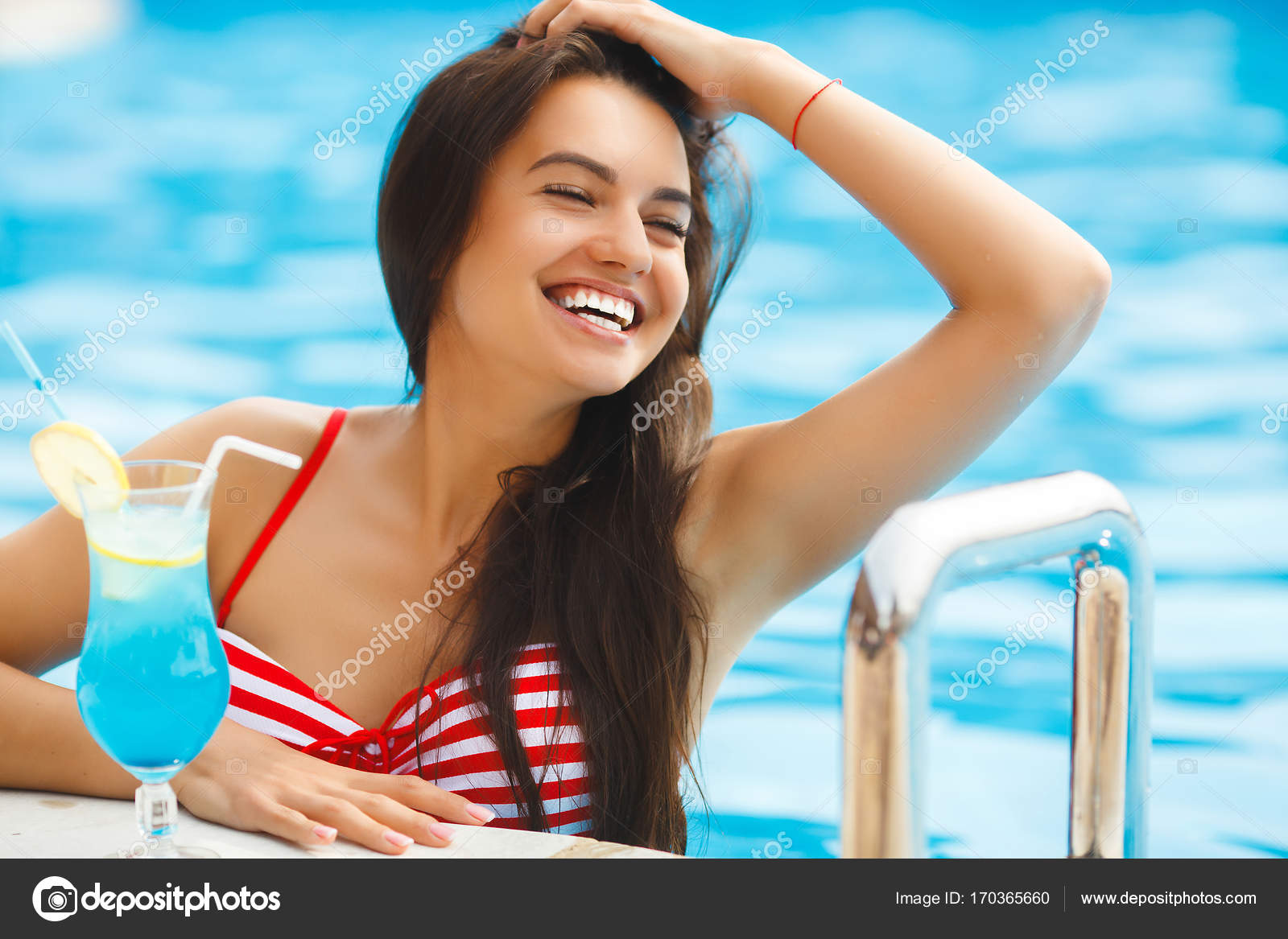 Hermosa mujer joven sentada en la tumbona junto a la piscina — Foto de