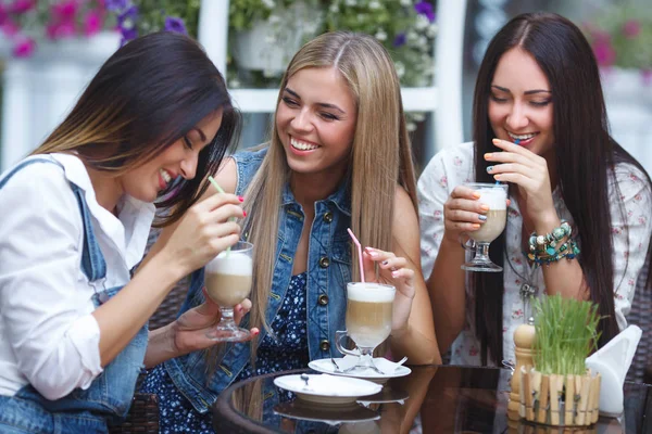 Группа из трех молодых привлекательных девушек, пьющих кофе в кафе — стоковое фото