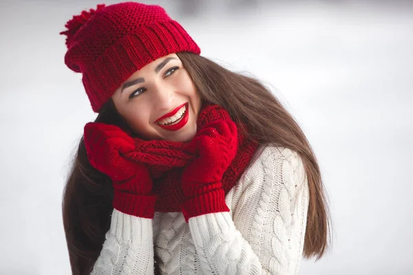Portret van een mooie vrouw op een winterse achtergrond. — Stockfoto